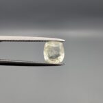 "Natural unheated Yellow Sapphire Pukhraj gemstone 1.46 carat cushion cut from Sri Lanka Ceylon held in tweezers showing pale near-colorless tone and natural inclusions"
