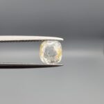 "Natural unheated Yellow Sapphire Pukhraj gemstone 1.97 carat cushion cut from Sri Lanka Ceylon held in tweezers showing near-colorless body with golden edge coloring"
