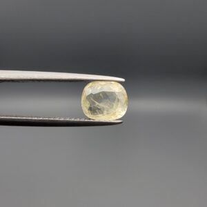 "Natural unheated Yellow Sapphire Pukhraj gemstone 1.92 carat cushion cut from Sri Lanka Ceylon held in tweezers showing soft yellow color and fine silky inclusions"