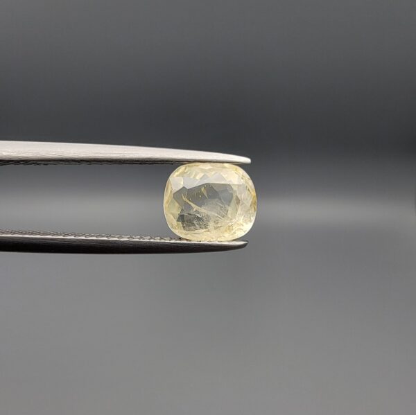 "Natural unheated Yellow Sapphire Pukhraj gemstone 1.92 carat cushion cut from Sri Lanka Ceylon held in tweezers showing soft yellow color and fine silky inclusions"