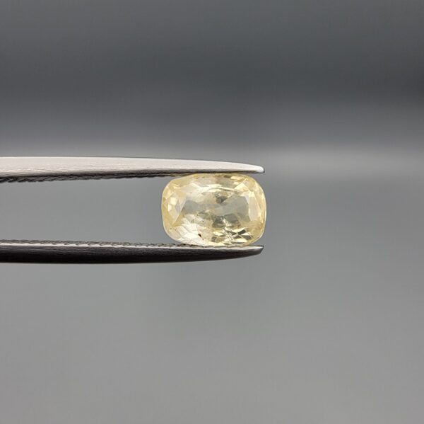 "Natural unheated Yellow Sapphire Pukhraj gemstone 1.62 carat cushion cut from Sri Lanka Ceylon held in tweezers showing warm golden color and natural inclusions"