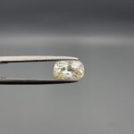 "Natural unheated Yellow Sapphire Pukhraj gemstone 1.66 carat elongated cushion cut from Sri Lanka Ceylon held in tweezers showing pale color with yellow patch and natural inclusions"
