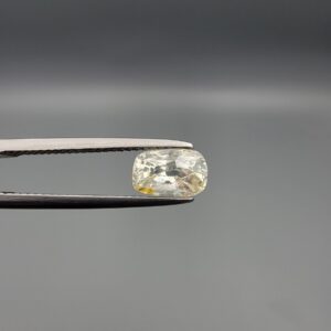 "Natural unheated Yellow Sapphire Pukhraj gemstone 1.66 carat elongated cushion cut from Sri Lanka Ceylon held in tweezers showing pale color with yellow patch and natural inclusions"