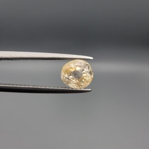 "Natural unheated Yellow Sapphire Pukhraj gemstone 1.98 carat round cut from Sri Lanka Ceylon held in tweezers showing bright golden color and natural inclusions"