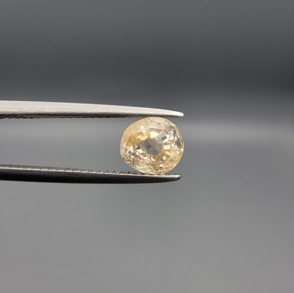 "Natural unheated Yellow Sapphire Pukhraj gemstone 1.98 carat round cut from Sri Lanka Ceylon held in tweezers showing bright golden color and natural inclusions"