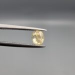 "Natural unheated Yellow Sapphire Pukhraj gemstone 1.05 carat oval cut from Sri Lanka Ceylon held in tweezers showing bright golden color and excellent brilliance"