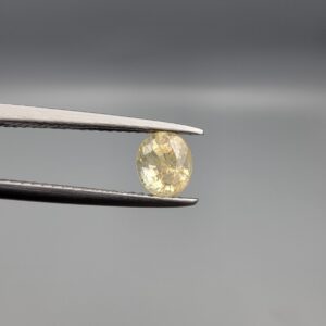 "Natural unheated Yellow Sapphire Pukhraj gemstone 1.05 carat oval cut from Sri Lanka Ceylon held in tweezers showing bright golden color and excellent brilliance"