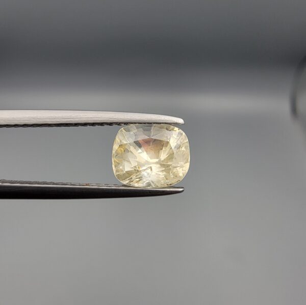 "Natural unheated Yellow Sapphire Pukhraj gemstone 1.99 carat cushion cut from Sri Lanka Ceylon held in tweezers showing bright faceting and natural inclusions"