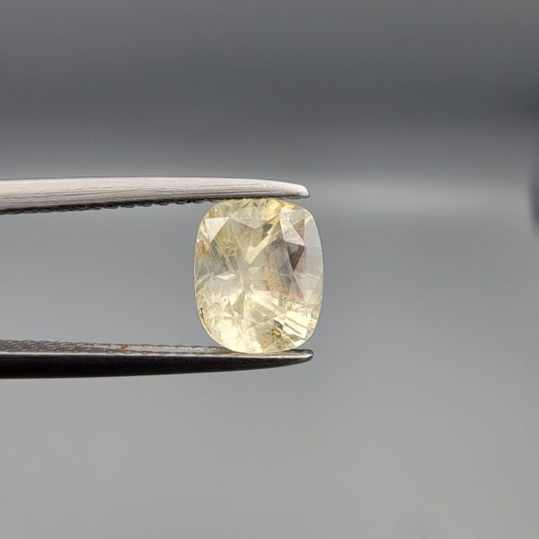 "Natural unheated Yellow Sapphire Pukhraj gemstone 1.99 carat cushion cut from Sri Lanka Ceylon held in tweezers showing bright faceting and natural inclusions"