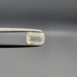 "Natural unheated Yellow Sapphire Pukhraj gemstone 1.24 carat elongated cushion cut from Sri Lanka Ceylon held in tweezers showing pale color and clean faceting"