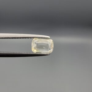 "Natural unheated Yellow Sapphire Pukhraj gemstone 1.24 carat elongated cushion cut from Sri Lanka Ceylon held in tweezers showing pale color and clean faceting"