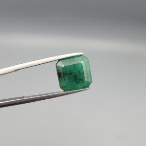"Natural Emerald Panna Zamrud gemstone 4.39 carat octagon emerald cut from Zambia held in tweezers showing deep green color and natural jardin inclusions"