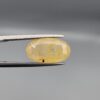 "Natural unheated Yellow Sapphire Pukhraj gemstone 10.60 carat large oval cut from Sri Lanka Ceylon held in tweezers showing golden color and visible natural fractures"