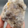 "Natural Fluorite crystal cluster specimen 1313 grams from Balochistan Pakistan showing large cubic purplish gray crystals with yellow limonite staining, held in hand"
