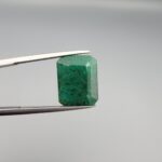 "Natural Emerald Panna Zamrud gemstone 9.26 carat octagon emerald cut from Swat Valley Pakistan held in tweezers showing deep green color and natural jardin inclusions"