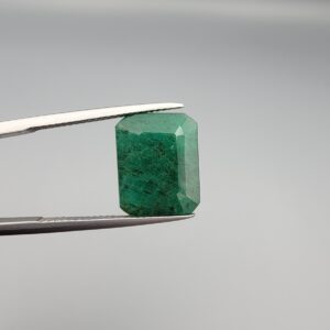 "Natural Emerald Panna Zamrud gemstone 9.26 carat octagon emerald cut from Swat Valley Pakistan held in tweezers showing deep green color and natural jardin inclusions"