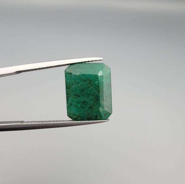 "Natural Emerald Panna Zamrud gemstone 9.26 carat octagon emerald cut from Swat Valley Pakistan held in tweezers showing deep green color and natural jardin inclusions"