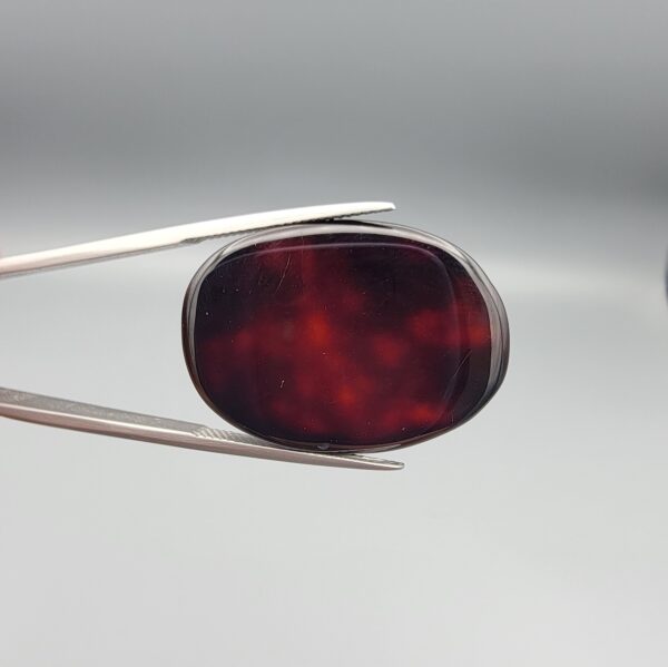 Natural Surkh Aqeeq oval cabochon 35.55 carat with translucent red black and cream marbled pattern from Iran