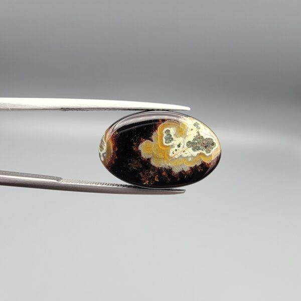 Natural black chalcedony agate oval cabochon 12.03 carat with cream and moss-green mineral inclusion from Iran