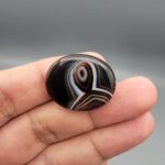 Natural black Sulemani agate oval cabochon 36.64 carat with natural pareidolia alien face pattern from Iran
