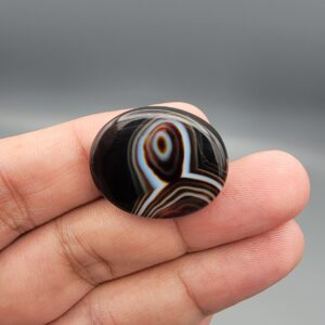 Natural black Sulemani agate oval cabochon 36.64 carat with natural pareidolia alien face pattern from Iran