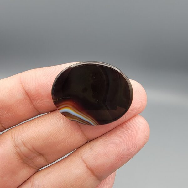 Natural black Sulemani agate oval cabochon 36.64 carat with natural pareidolia alien face pattern from Iran