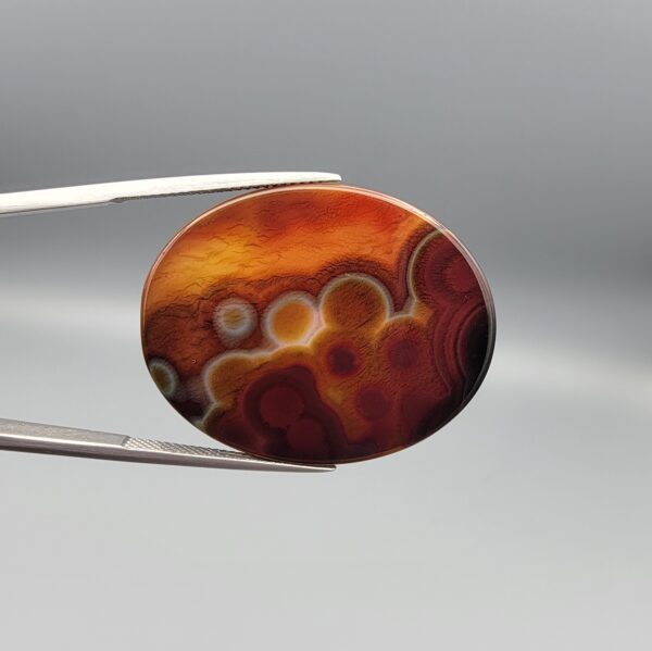 Natural Sulemani agate oval cabochon 64.07 carat with black white orbicular bubble pattern and warm amber reverse from Iran