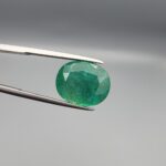 Natural green Zambian emerald oval faceted gemstone 8.75 carat with visible mineral inclusions