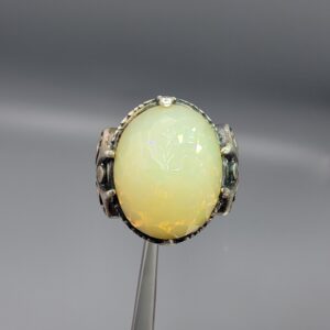Studio photograph of a handcrafted men's 925 sterling silver ring featuring a massive 8+ carat natural faceted Ethiopian opal center stone with intricate vintage Turkish scrollwork on the shoulders.