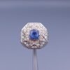 Studio close-up photograph of a handcrafted 925 sterling silver men's ring featuring a central 2+ carat blue sapphire surrounded by a geometric star design pavé-set with natural diamonds.