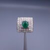 Studio close-up photograph of a handcrafted size 23 men's 925 sterling silver ring centered with a 1.60 carat oval emerald framed by a double rectangular tier of pavé-set natural diamonds.