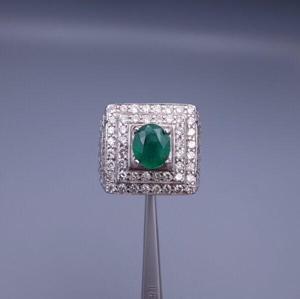 Studio close-up photograph of a handcrafted size 23 men's 925 sterling silver ring centered with a 1.60 carat oval emerald framed by a double rectangular tier of pavé-set natural diamonds.