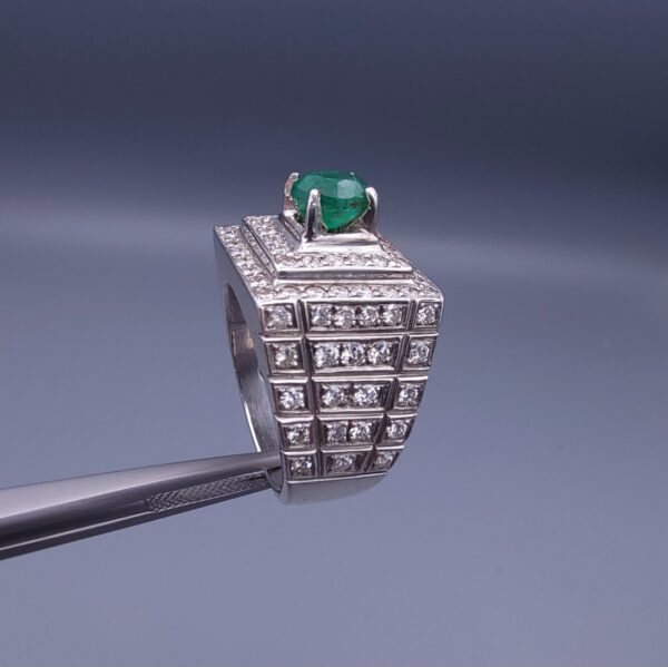 Studio close-up photograph of a handcrafted size 23 men's 925 sterling silver ring centered with a 1.60 carat oval emerald framed by a double rectangular tier of pavé-set natural diamonds.