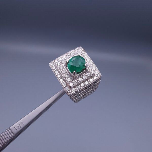 Studio close-up photograph of a handcrafted size 23 men's 925 sterling silver ring centered with a 1.60 carat oval emerald framed by a double rectangular tier of pavé-set natural diamonds.