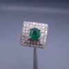 Studio close-up photograph of a handcrafted size 23 men's 925 sterling silver ring centered with a 1.60 carat oval emerald framed by a double rectangular tier of pavé-set natural diamonds.
