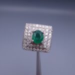 Studio close-up photograph of a handcrafted size 23 men's 925 sterling silver ring centered with a 1.60 carat oval emerald framed by a double rectangular tier of pavé-set natural diamonds.