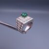 Studio close-up photograph of a handcrafted size 23 men's 925 sterling silver ring centered with a 1.60 carat oval emerald framed by a double rectangular tier of pavé-set natural diamonds.