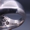 Studio close-up photograph of a handcrafted 925 sterling silver men's ring featuring a central 2+ carat blue sapphire surrounded by a geometric star design pavé-set with natural diamonds.