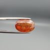 Studio close-up photographs showing the front and back view of a 10.74 carat oval-cut natural hessonite garnet gemstone displaying a warm honey-orange color and semi-transparent clarity.