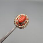 Studio close-up photographs showing the top and side profile views of a handcrafted 925 sterling silver ring featuring a natural Italian coral center stone and matching coral side accents.