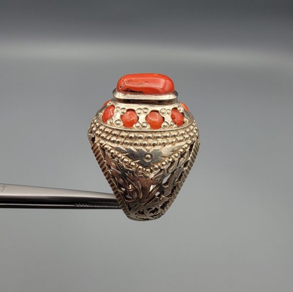 Studio close-up photographs showing the top and side profile views of a handcrafted 925 sterling silver ring featuring a natural Italian coral center stone and matching coral side accents.