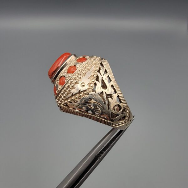 Studio close-up photographs showing the top and side profile views of a handcrafted 925 sterling silver ring featuring a natural Italian coral center stone and matching coral side accents.