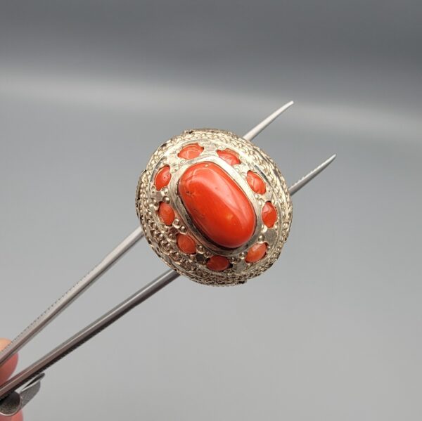 Studio close-up photographs showing the top and side profile views of a handcrafted 925 sterling silver ring featuring a natural Italian coral center stone and matching coral side accents.
