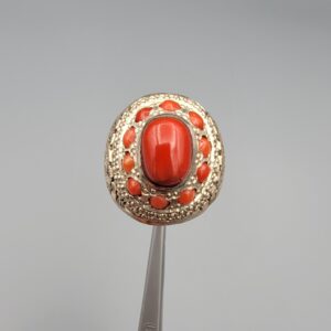 Studio close-up photographs showing the top and side profile views of a handcrafted size 22 solid 925 sterling silver ring featuring a natural Italian coral center stone and matching coral side accents.