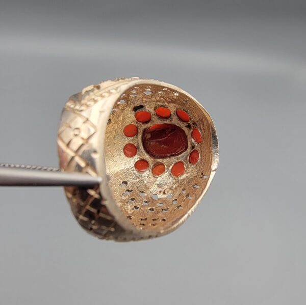 Studio close-up photographs showing the top and side profile views of a handcrafted size 22 solid 925 sterling silver ring featuring a natural Italian coral center stone and matching coral side accents.