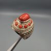 Studio close-up photographs showing the top and side profile views of a handcrafted size 22 solid 925 sterling silver ring featuring a natural Italian coral center stone and matching coral side accents.