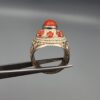 Studio close-up photographs showing the top and side profile views of a handcrafted size 22 solid 925 sterling silver ring featuring a natural Italian coral center stone and matching coral side accents.