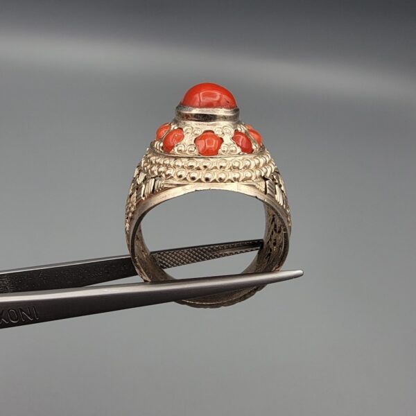 Studio close-up photographs showing the top and side profile views of a handcrafted size 22 solid 925 sterling silver ring featuring a natural Italian coral center stone and matching coral side accents.