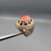 Studio close-up photographs showing the top and side profile views of a handcrafted size 23 solid 925 sterling silver ring featuring a natural Italian coral center stone surrounded by faceted garnet accent stones.