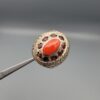 Studio close-up photographs showing the top and side profile views of a handcrafted size 23 solid 925 sterling silver ring featuring a natural Italian coral center stone surrounded by faceted garnet accent stones.